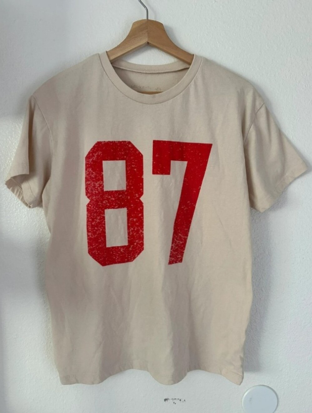 Travis Kelce Grayson Threads Cream Short Sleeve Tee with Red '87' Graphic